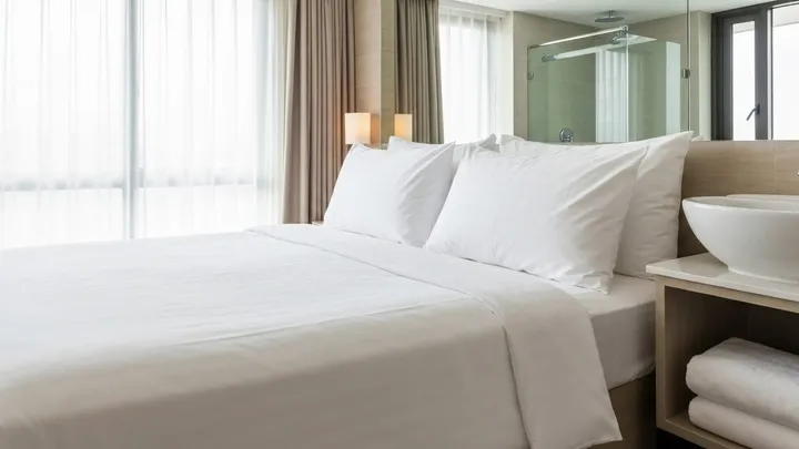 เตียงปูผ้าขาวใหม่มาตรฐานโรงแรมระหว่าง turnover